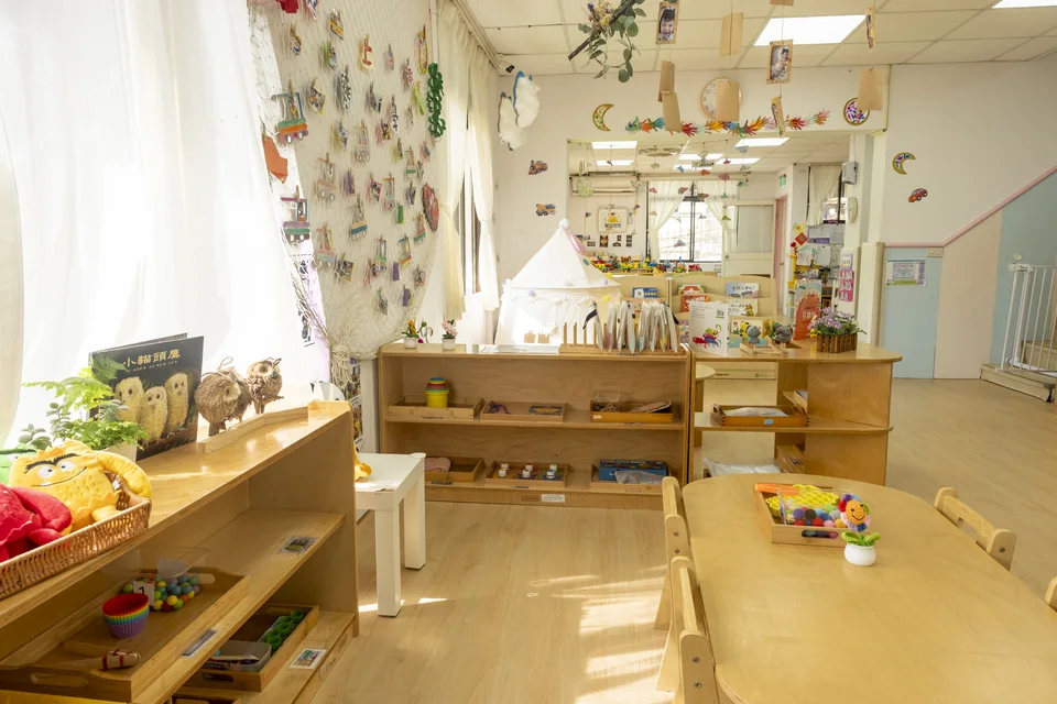 聖育幼兒園教室的另一個視角，窗邊有木質教具櫃與孩子作品